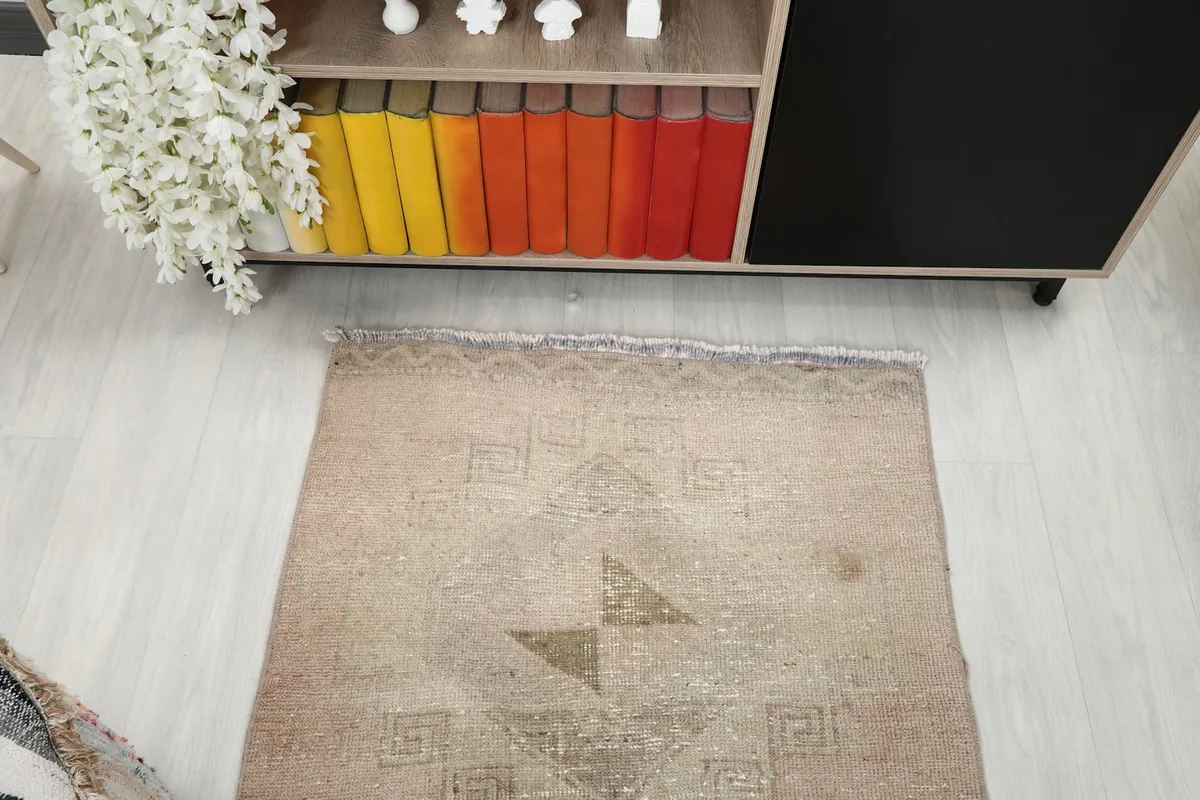 Overhead shot of the runner's end, highlighting the faded tribal design and natural patina.
