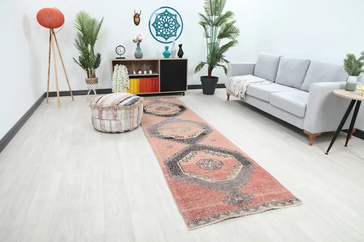 Angle view of the rose and charcoal geometric runner rug in a room setting with furniture