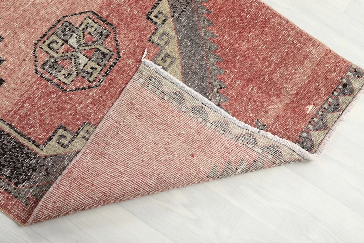 Corner of the runner folded to show the hand-knotted wool pile and cotton foundation from the back