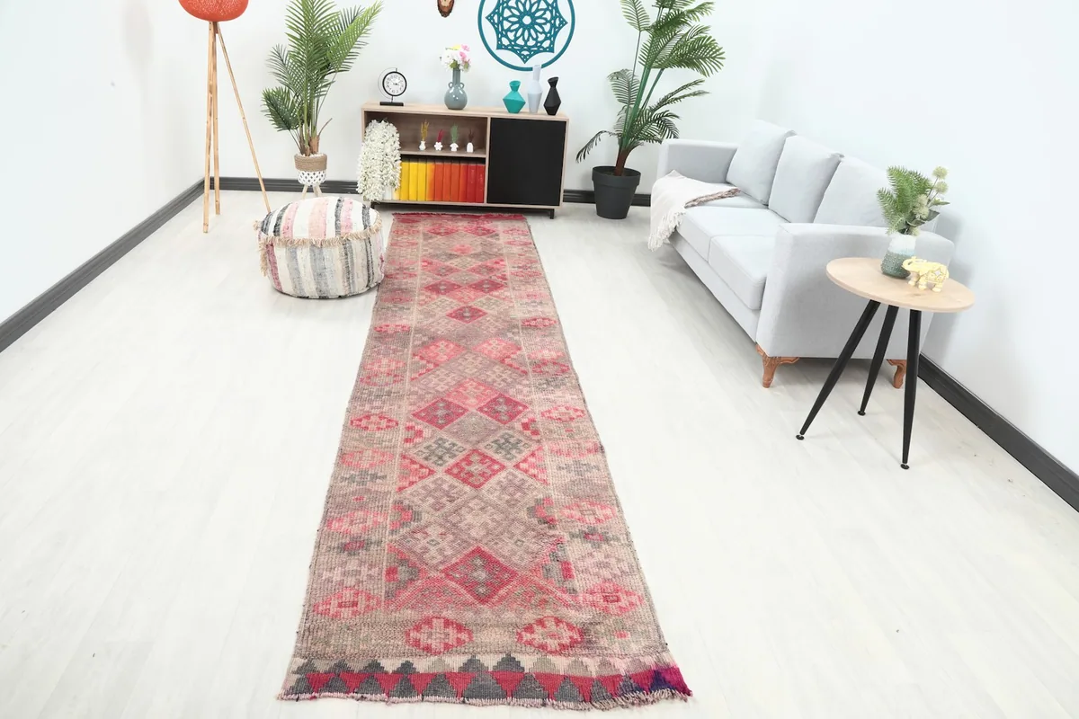 Vintage runner rug laid out in a modern hallway with a light gray couch and decorative plants