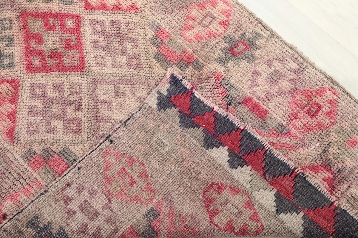 View of the back of the rug, revealing the hand-knotted construction and cotton foundation