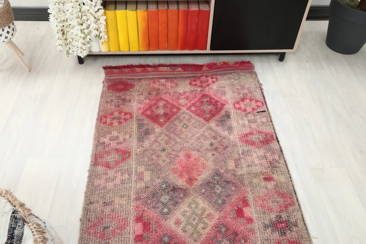Overhead view of one end of the runner rug, showing the pattern near a bookshelf