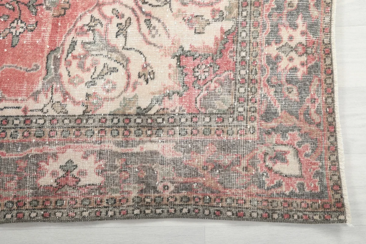Detail of the gray and ivory floral border pattern on the vintage rug