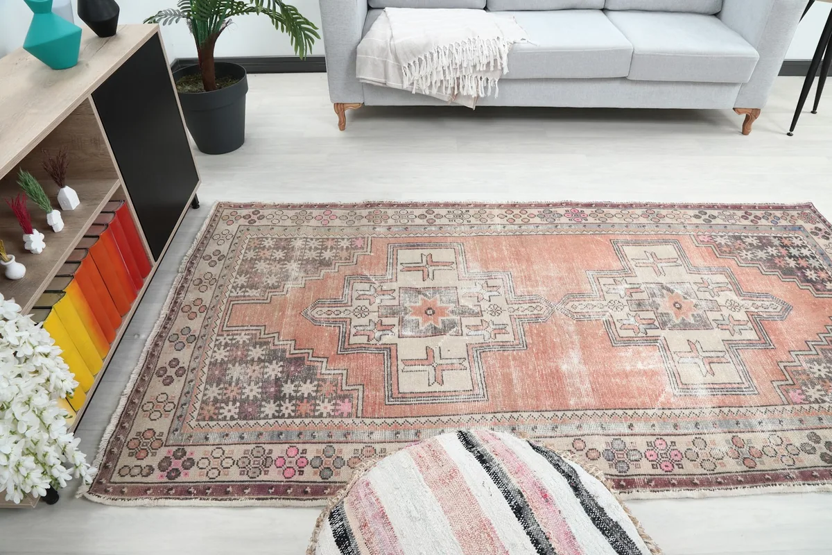 Wide shot of the orange and beige rug in a room, showing its scale relative to a sofa and decor.
