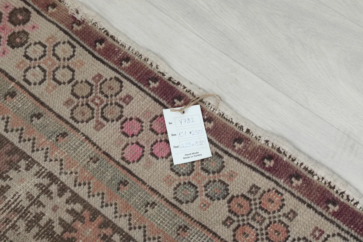 Corner of the rug with a product tag, showing the texture and fringe detail.