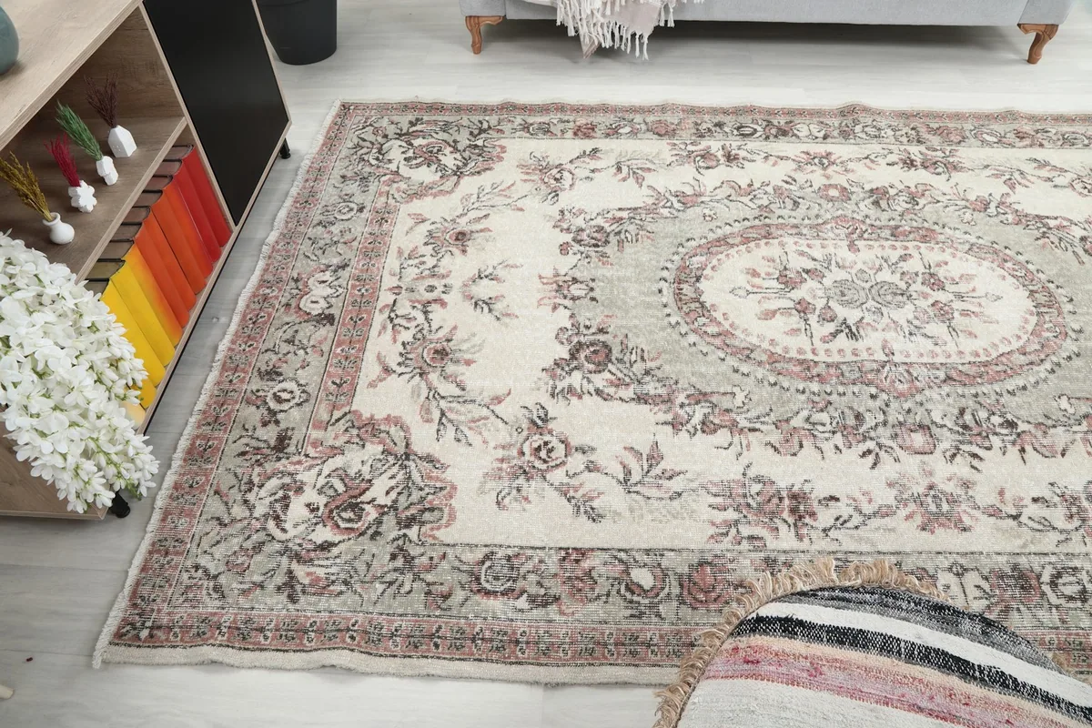 Wide angle view of the ivory and rose rug in a room, showing its large size and placement