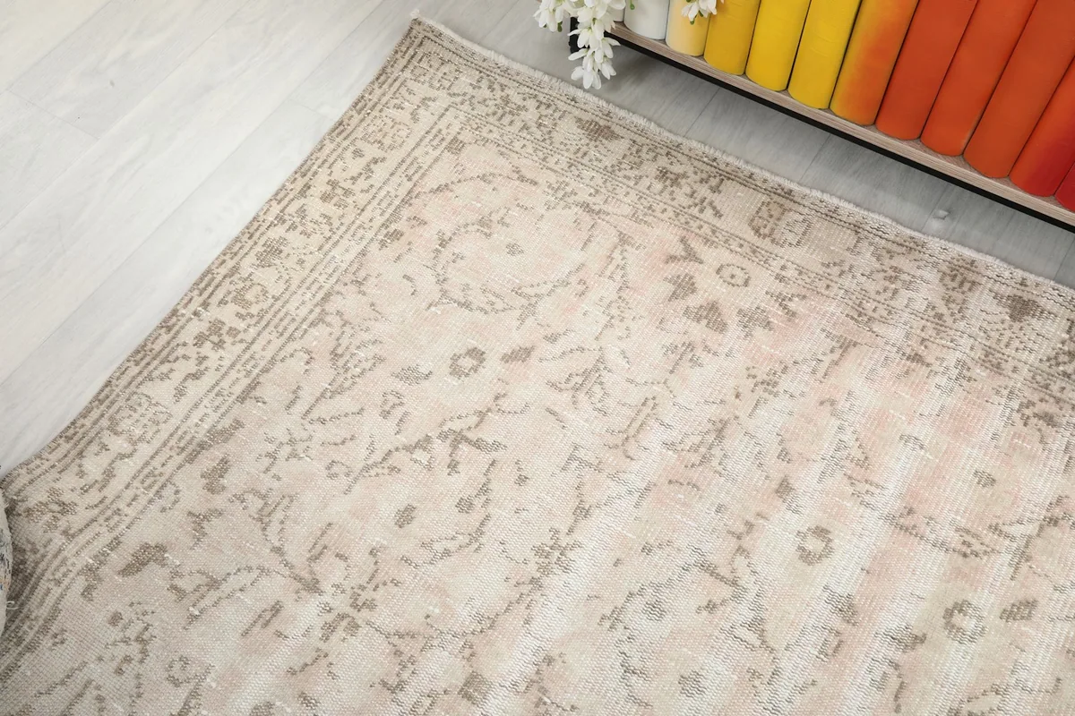 Angled view from a different perspective, showing the rug's faded design and border details