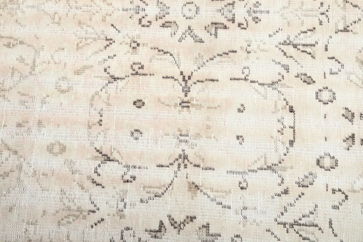 Close-up of the central floral and geometric motifs on the beige field of the rug