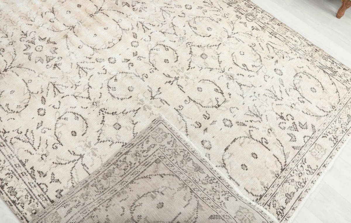 Corner of the rug folded back to reveal the cotton foundation and hand-knotted construction