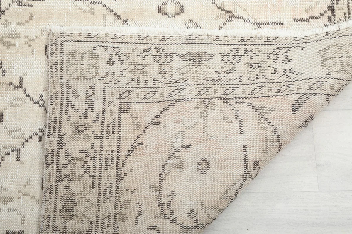 Another view of the rug's underside, showing the tightly woven cotton foundation and knotting