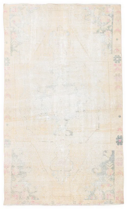 Full overhead view of the vintage ivory and rose geometric Anatolian rug on a white background.