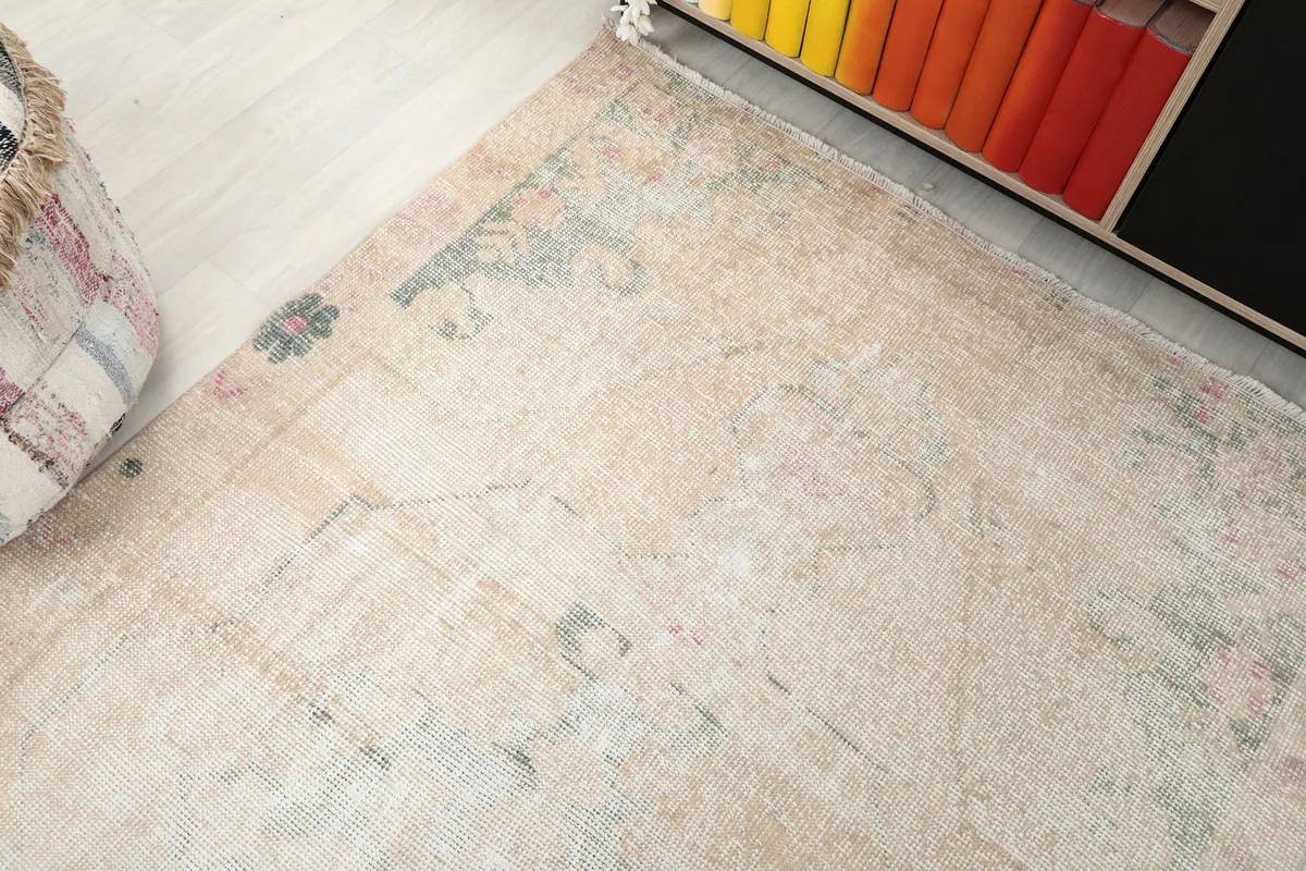 Overhead angled shot of the rug's corner, revealing geometric details and distressed areas.