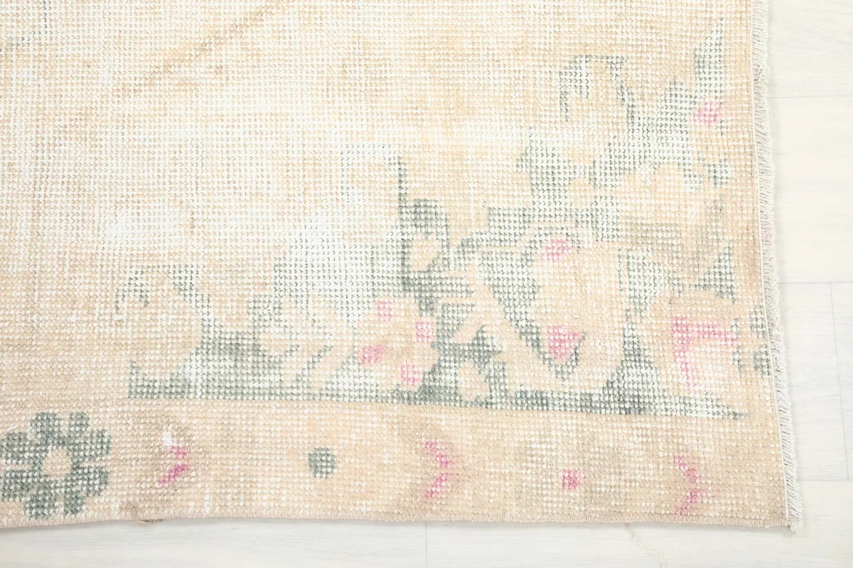 Close-up of the rug's border showing rose and green geometric patterns.