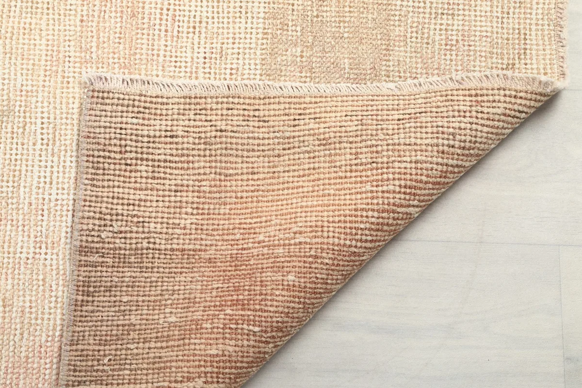 Close-up of the rug's underside, showing the intricate hand-knotted construction on cotton foundation.