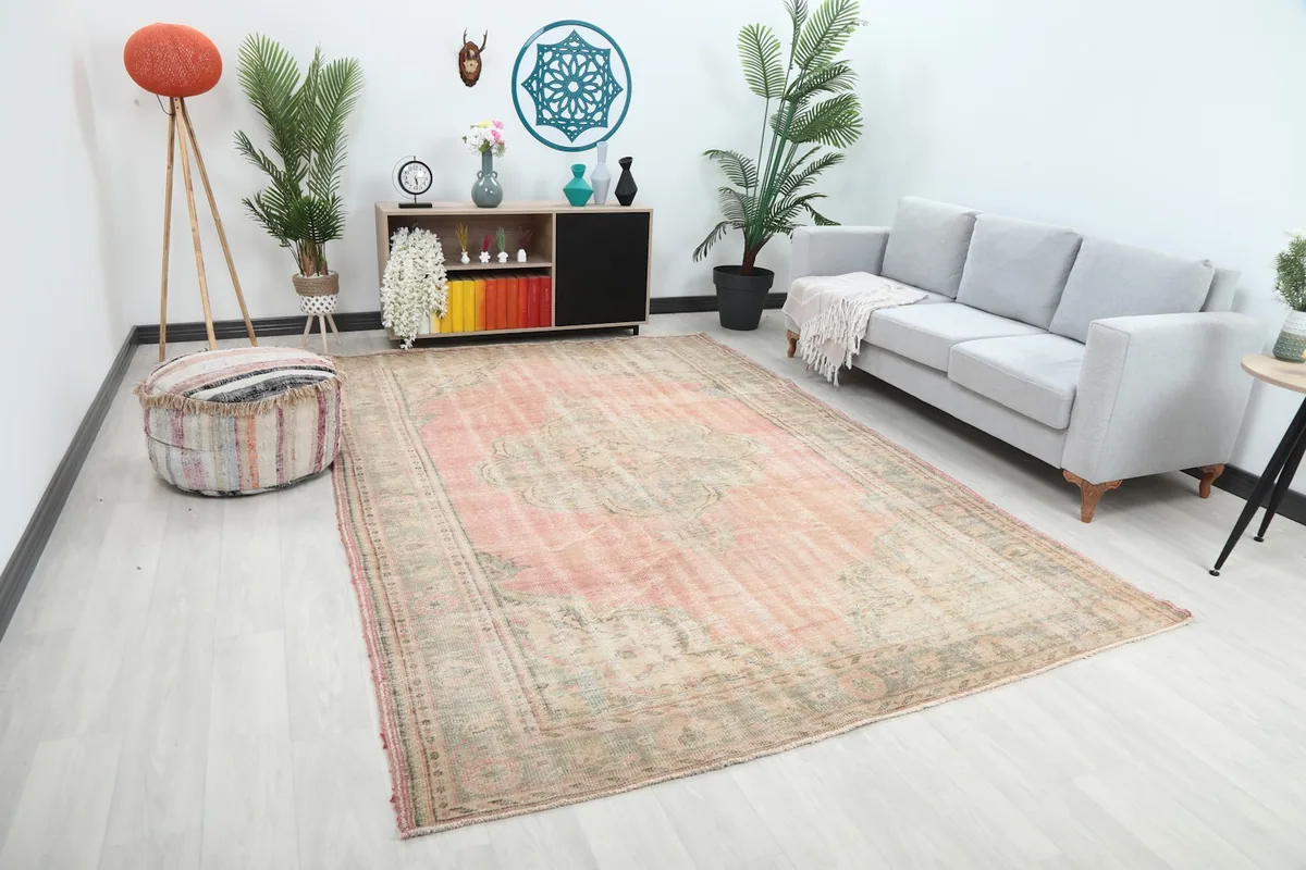 Angle view of the rose and beige vintage rug in a modern living room with decorative elements.