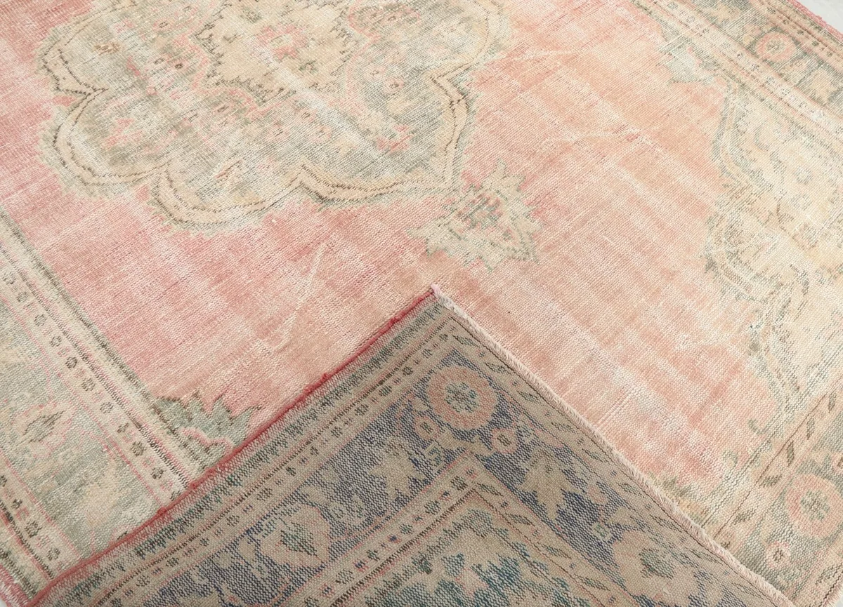 Corner of the rug folded back to reveal the hand-knotted cotton foundation and wool pile.