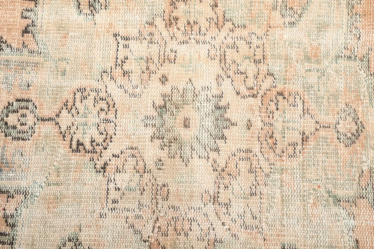 Macro shot of the rug's texture and intricate patterns within the medallion, showing wool fibers