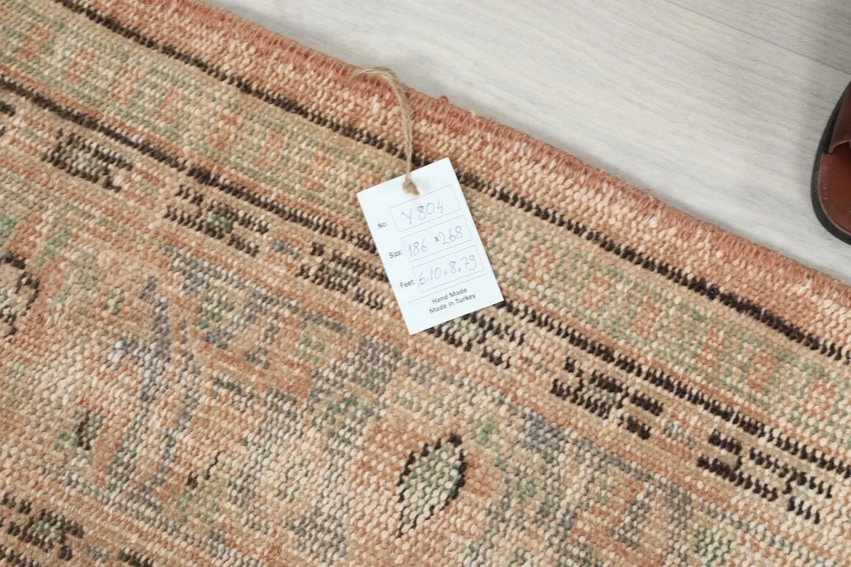 Close-up of the rug's back with a tag, detailing the hand-knotted wool on cotton construction