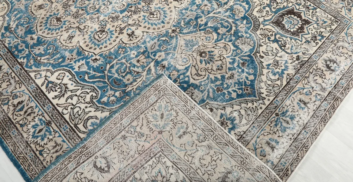 Folded corner of the rug revealing the cotton foundation and reverse side of the knots