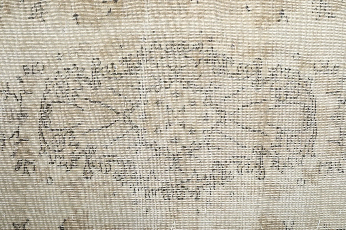 Close-up of the central medallion design, showing the subtle variations in gray and beige tones