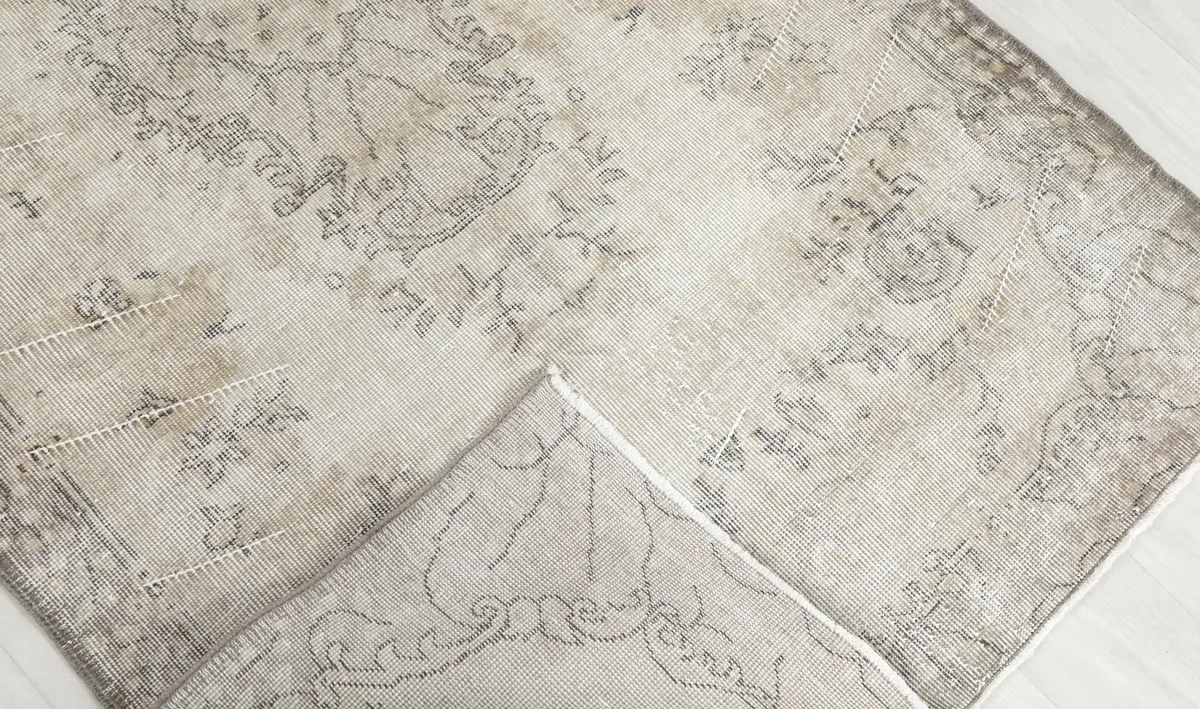 Corner of the rug folded back to reveal the back of the hand-knotted wool pile