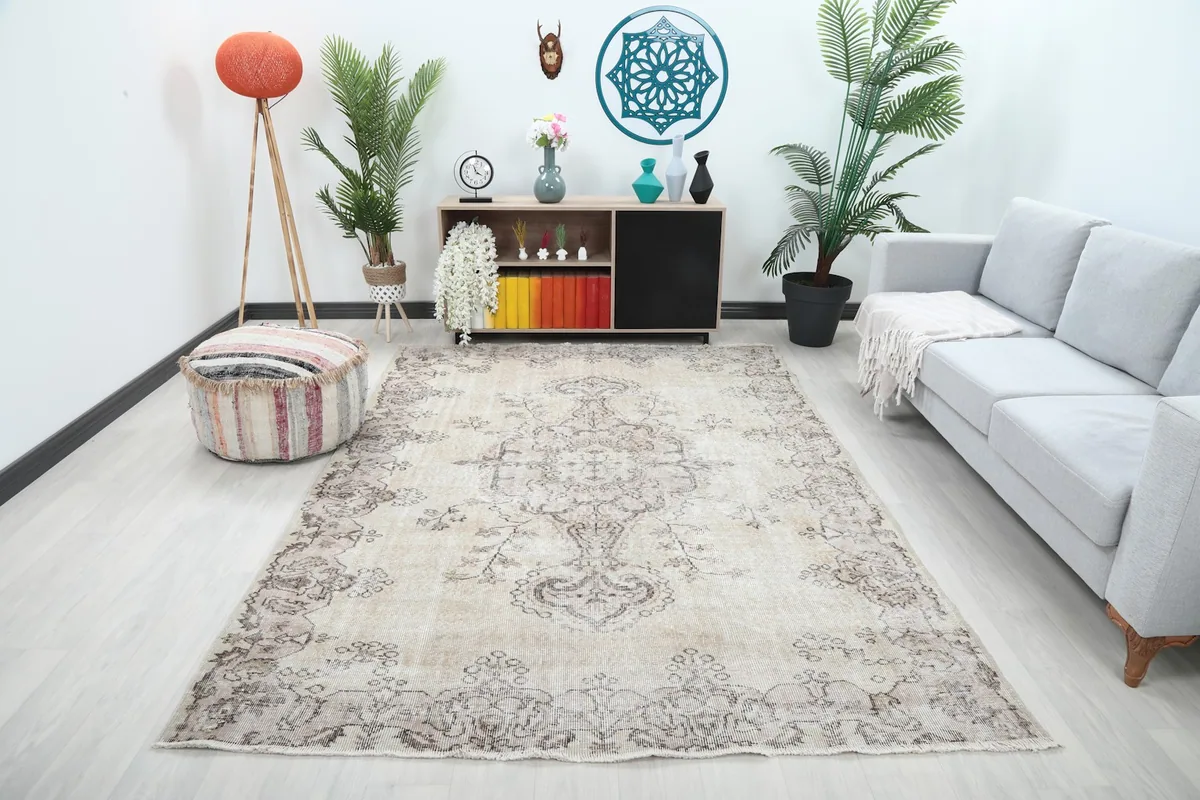 Ivory and gray vintage rug in a living room setting with a sofa and decor