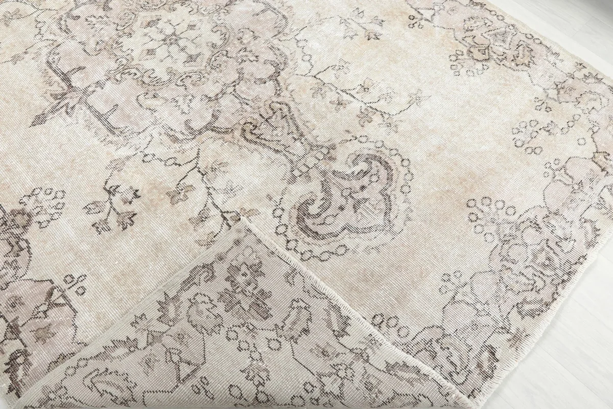 Corner of the hand-knotted wool rug folded back, showing the cotton foundation