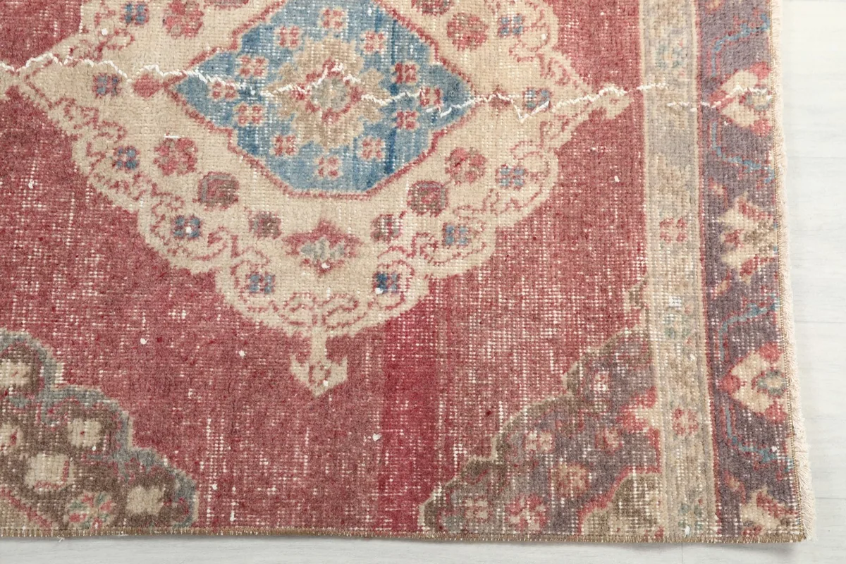 Close-up detail of a central medallion with blue and beige tones on the rose background