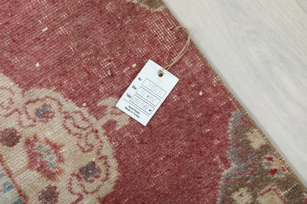 Close-up of the rug's surface with a product tag, indicating its vintage origin