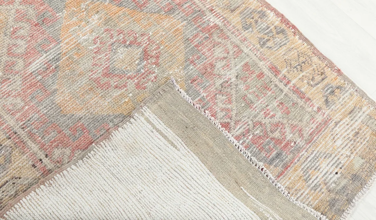 View of the back of the hand-knotted rug, revealing the cotton foundation