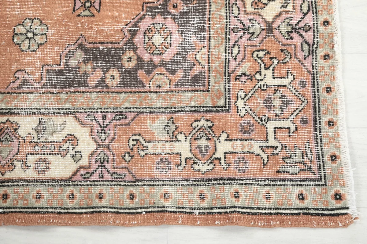 Detailed view of the corner motif and border design on the vintage rug