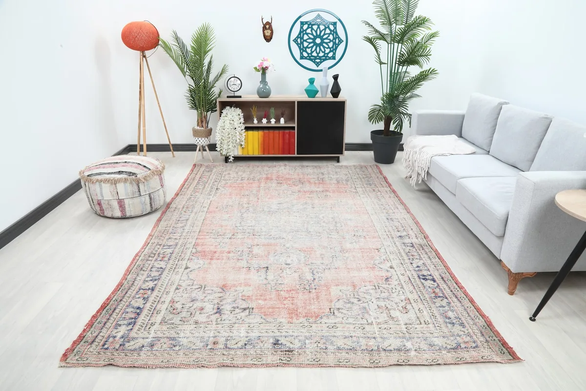 Vintage area rug displayed in a living room setting with a gray sofa