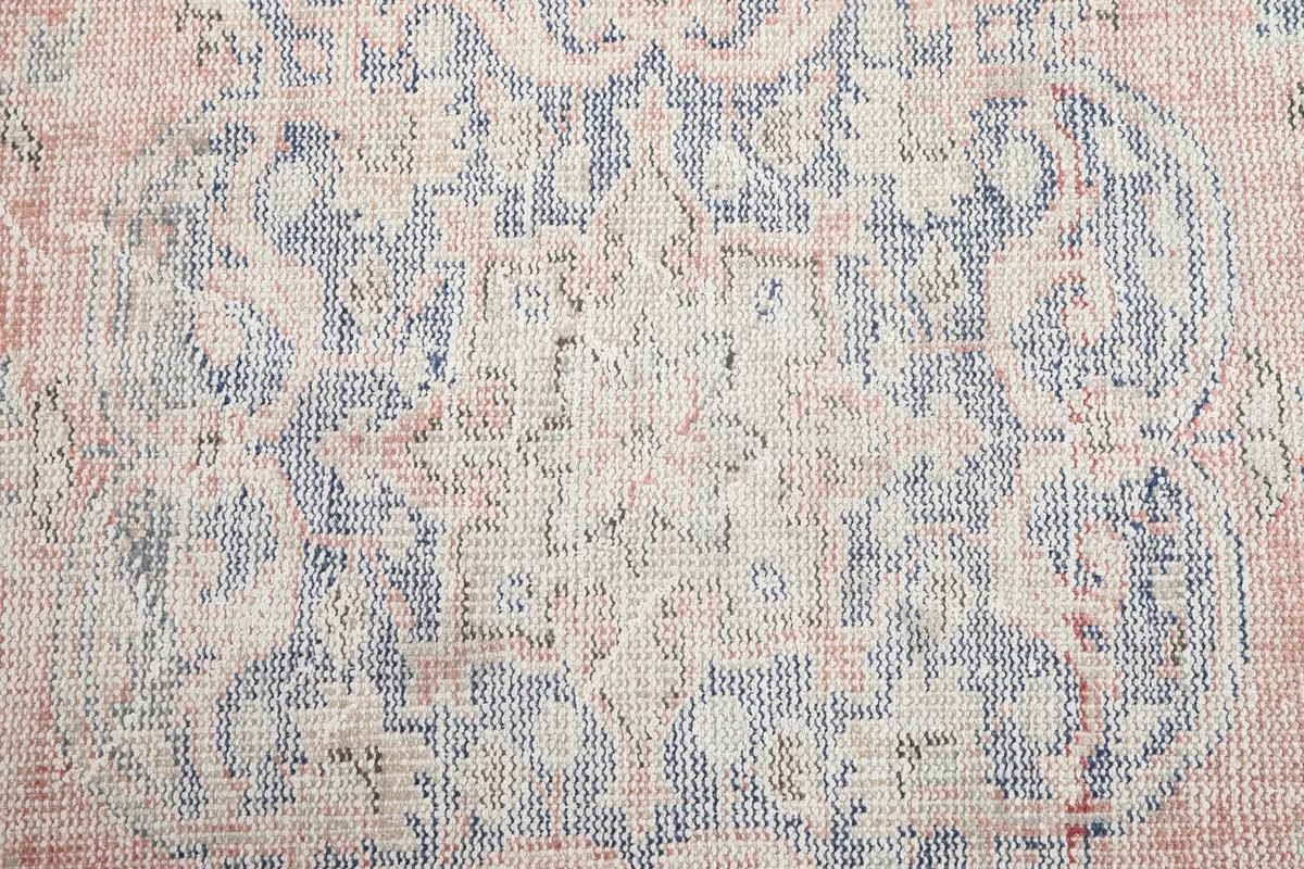 Texture and color detail of the hand-knotted wool pile showing blue and rose threads