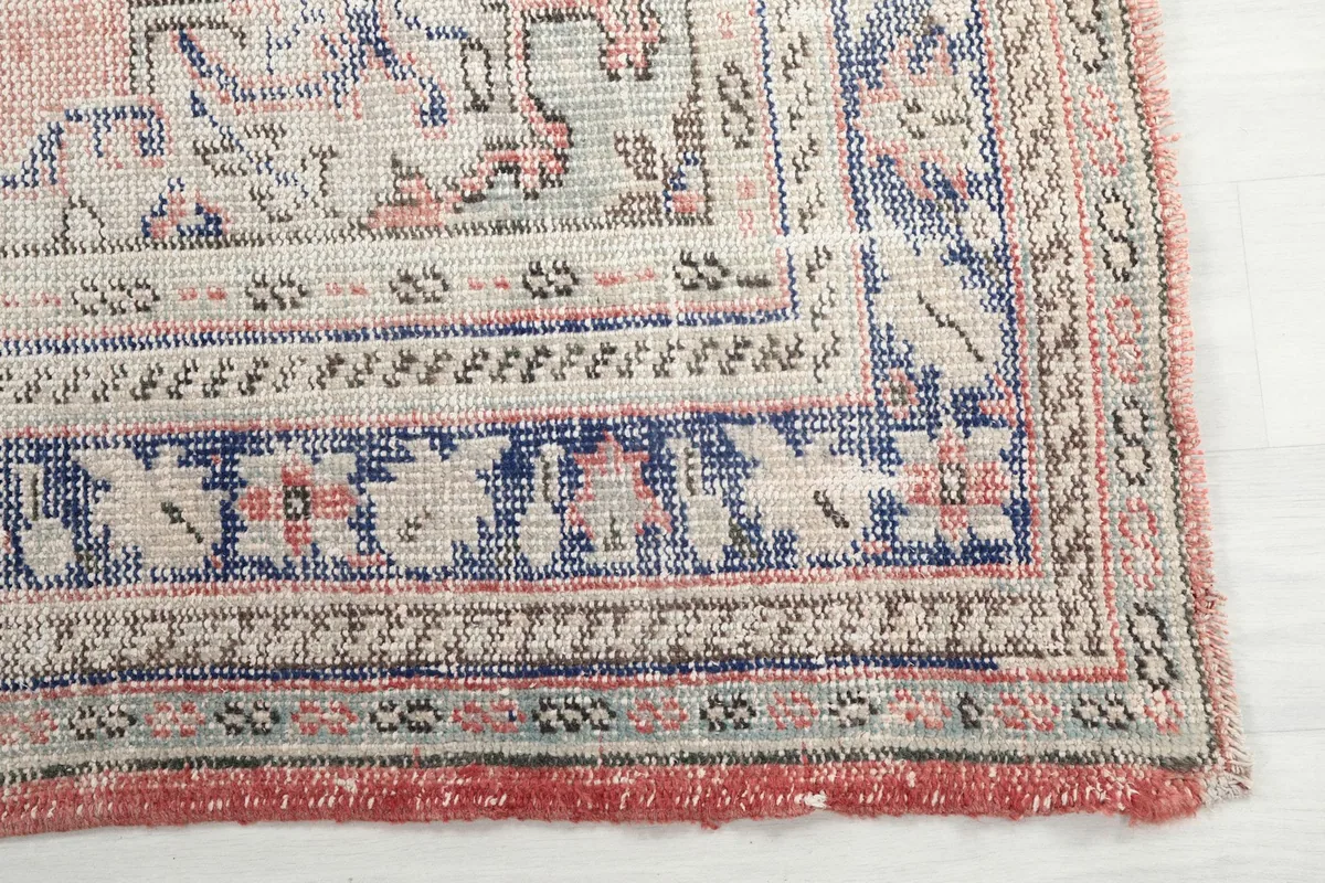 Detailed view of the intricate blue and beige patterns on the rug's border