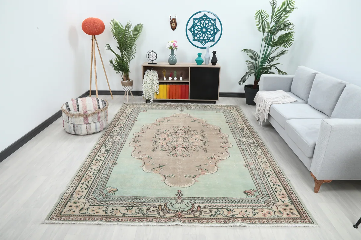 Faded Green Floral Medallion Rug in a room setting, showcasing its size and colors with furniture.