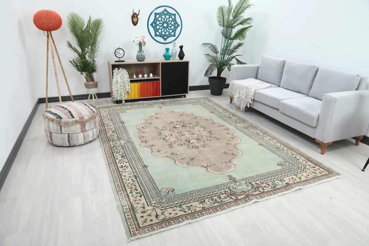 Faded Green Floral Medallion Rug in a room from a slightly different angle, highlighting its placement.