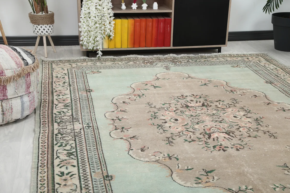 Close-up view of the Faded Green Floral Medallion Rug's corner and part of the central field.