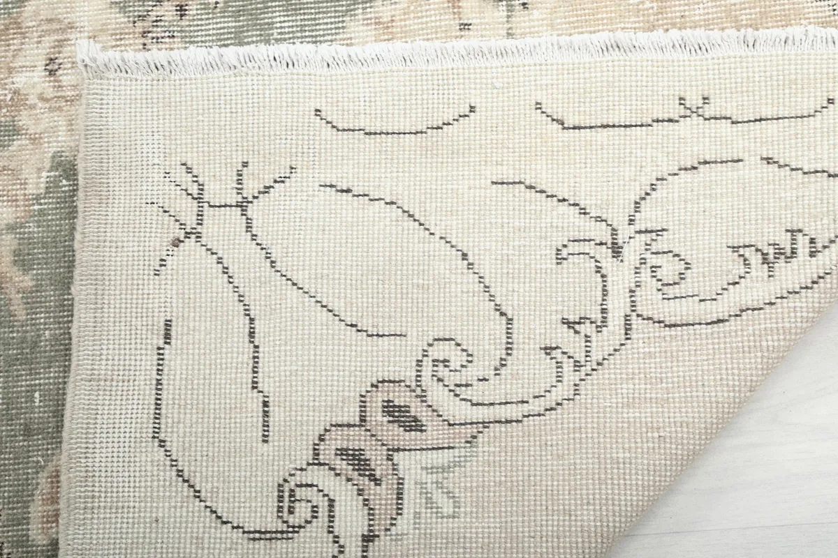 Close-up of the rug's back and natural fringe, demonstrating its construction.
