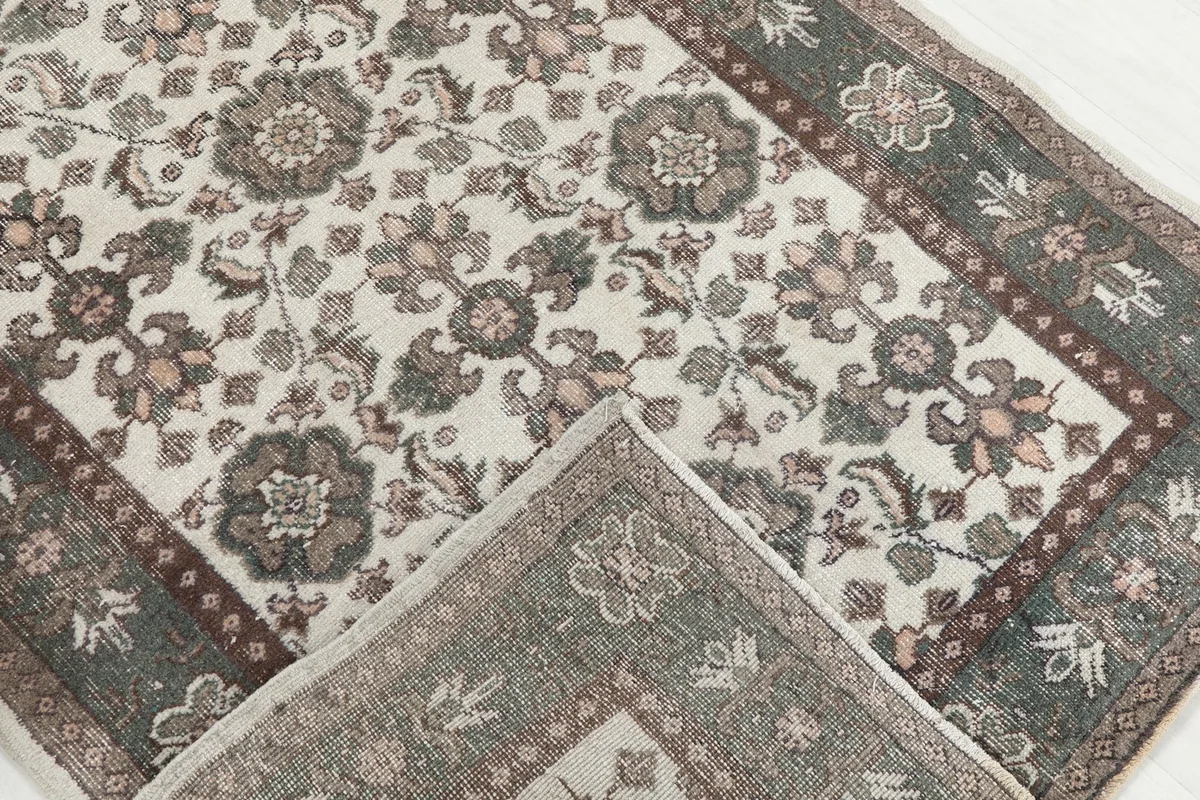 Corner of the rug folded back to reveal the back of the hand-knotted construction