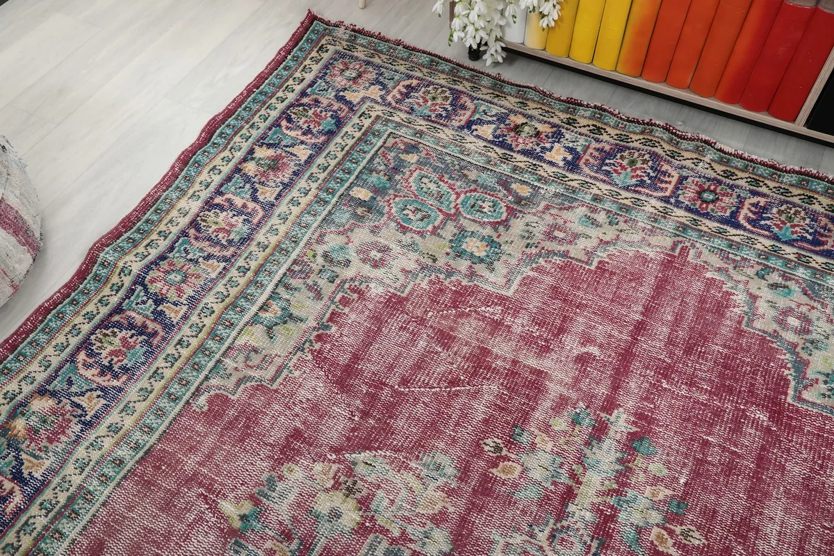 Corner view of the rug showing the transition from the rose field to the detailed navy border