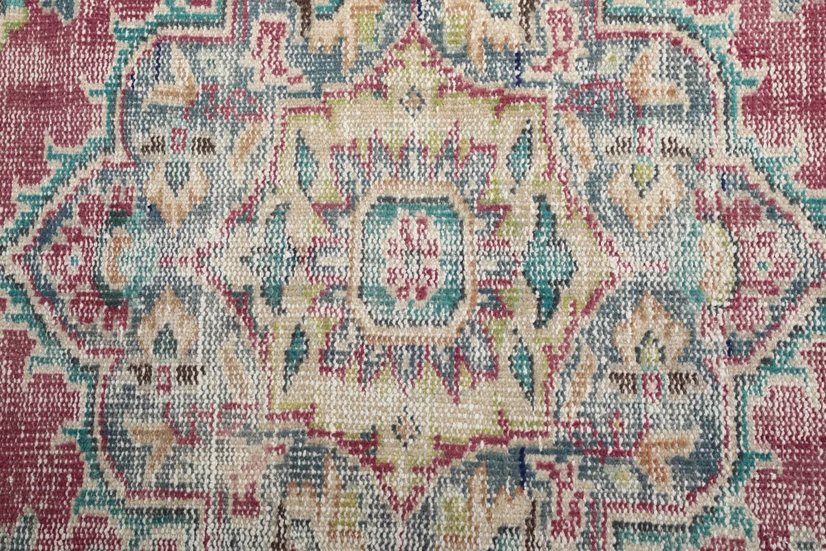 Detailed close-up of the central medallion design with beige, light blue, and olive tones
