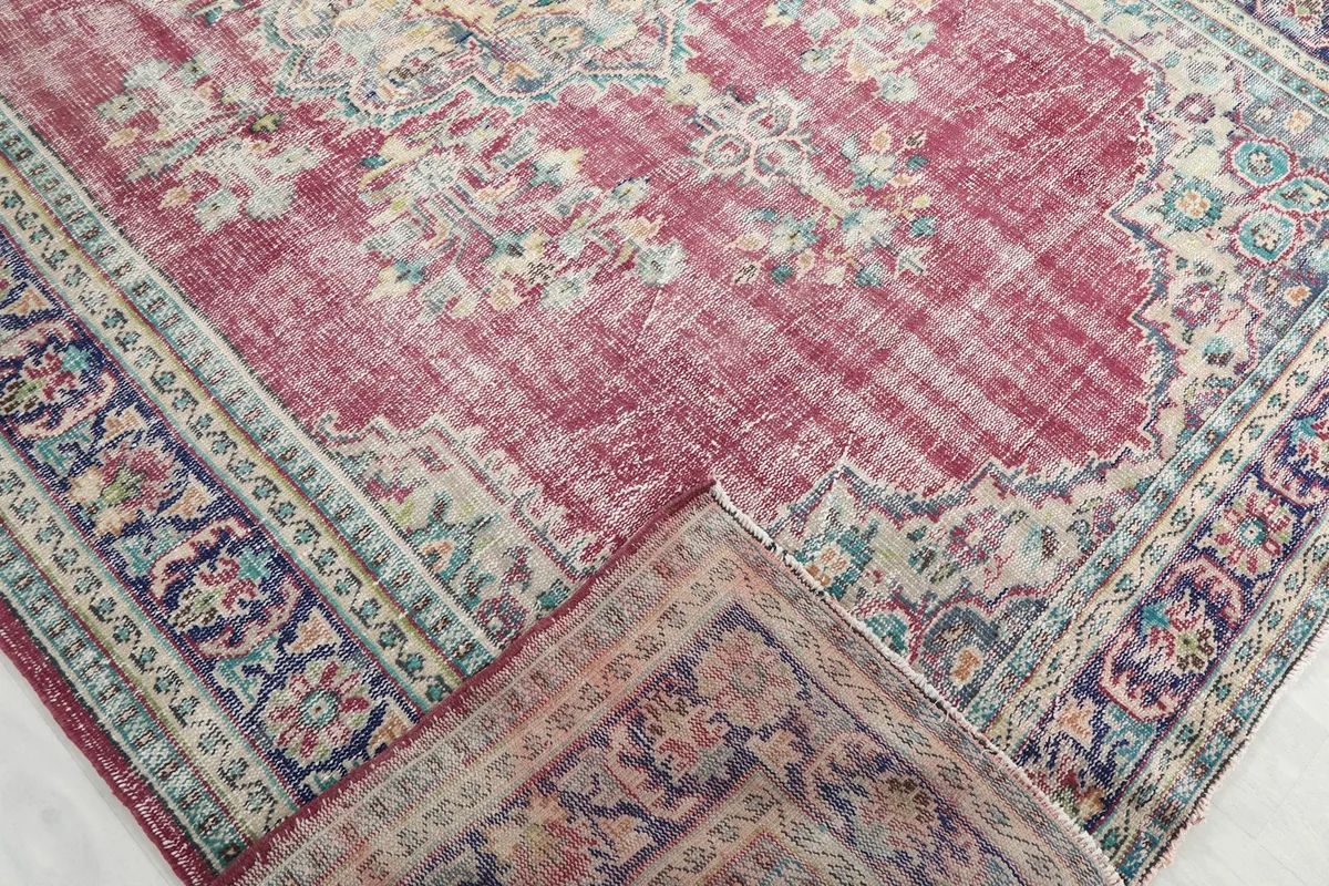 View of a folded corner of the rug, revealing the wool pile and cotton foundation