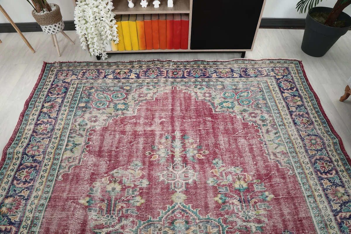 Overhead view of the vintage rug showcasing its overall design and faded rose color