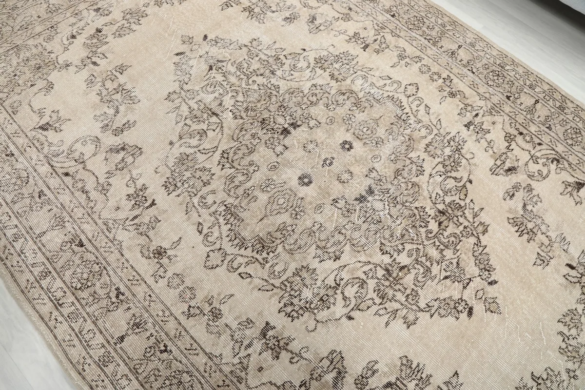 Close-up of the central medallion and surrounding floral design, highlighting the aged patina.