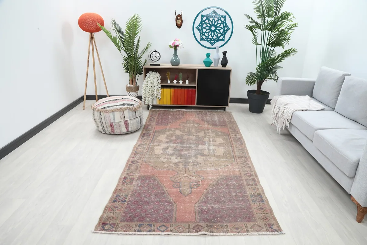 Full view of the vintage rug placed in a modern living space with a sofa and plants