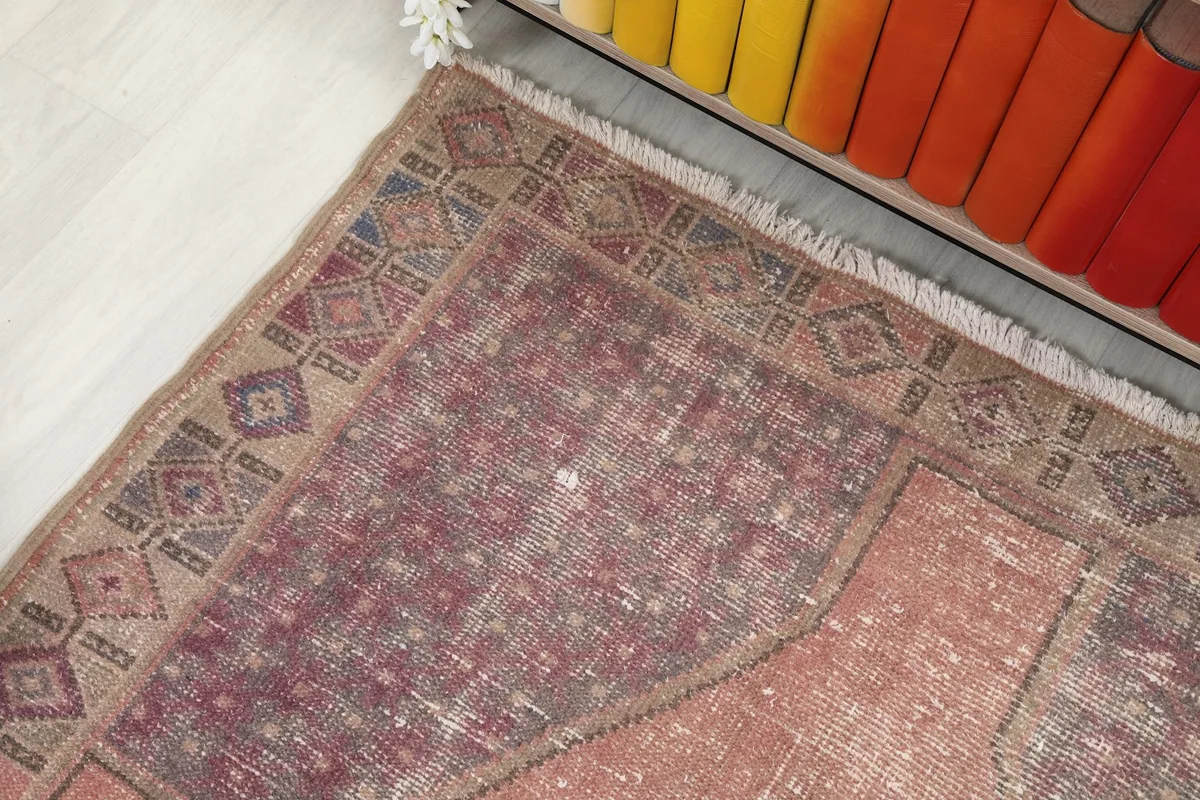 Overhead detail of the rug's end border and field, showing the blend of colors and motifs