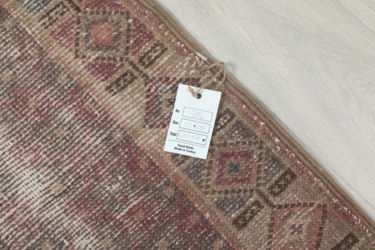 Detail of the rug's corner with a product tag, confirming its hand-knotted origin