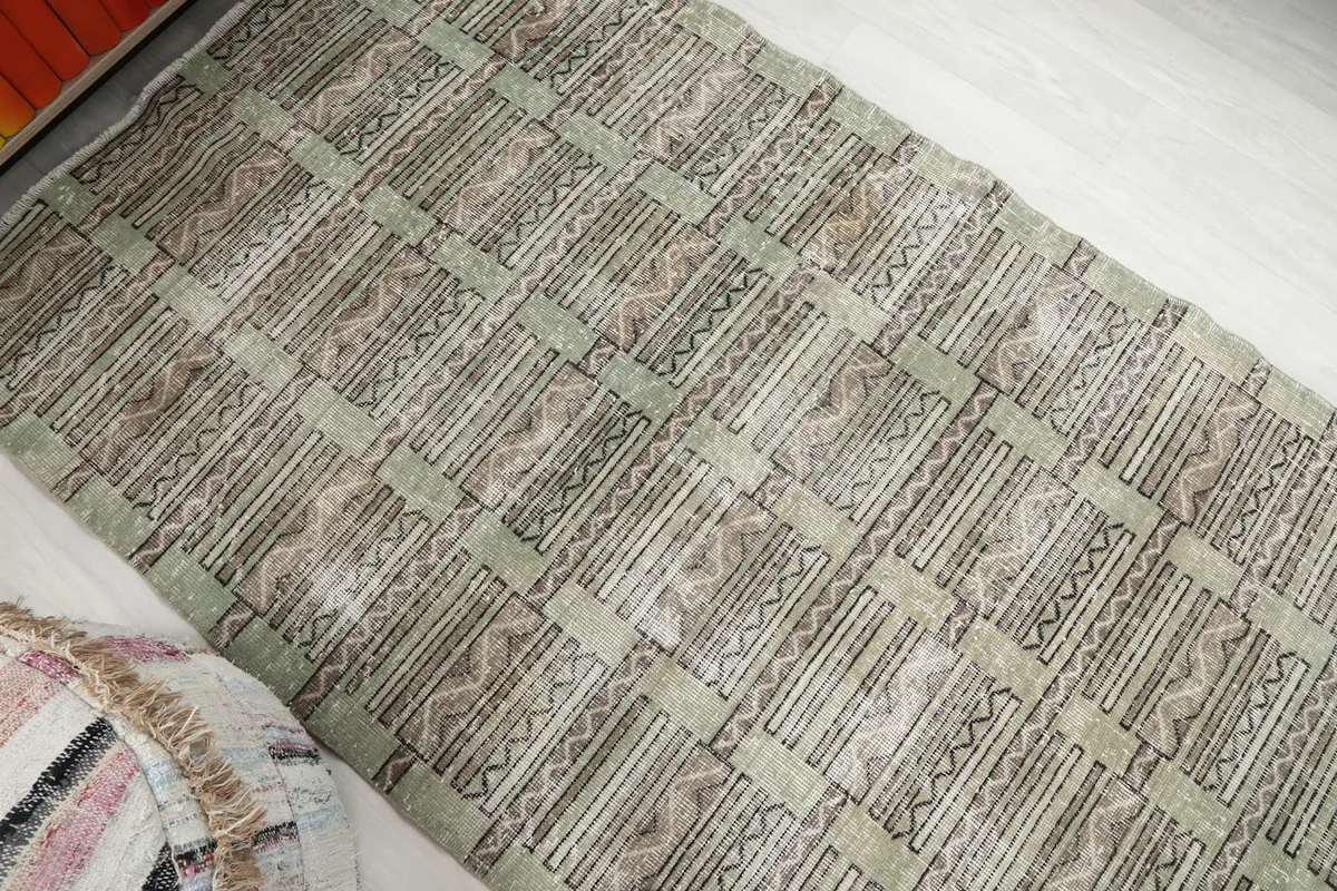 Overhead angle view of the olive area rug, highlighting its full pattern