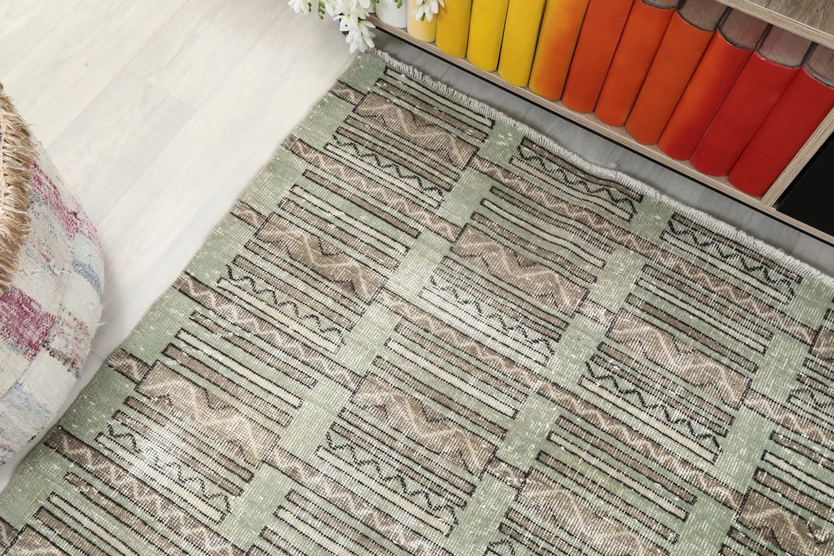 Corner view of the rug showing the geometric pattern and light wear