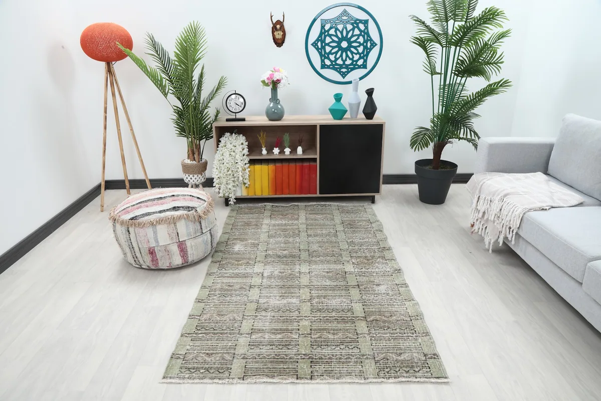 Olive geometric tribal rug in a living room setting with a sofa and decor